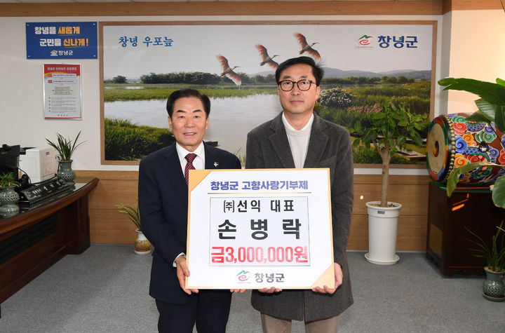 [창녕=뉴시스] 성낙인(왼쪽) 군수와 손병락 대표가 고향사랑기부금 기탁식에 이어 기념촬영을 하고 있다. (사진= 창녕군 제공) 2025.12.09. photo@newsis.com *재판매 및 DB 금지