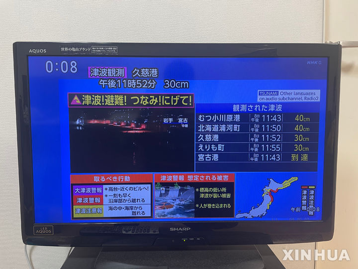 [도쿄=신화] 9일 일본 도쿄에서 휴대전화로 촬영한 사진에 지진 정보가 TV 화면에 표시돼 있다. 일본 기상청은 8일 오후 11시 15분경 아오모리현 앞바다에서 규모 7.6의 지진이 발생했다고 밝혔다. 이번 지진으로 태평양 연안 일부 지역에서 쓰나미가 관측됐고, 9일 새벽 여진도 발생했다. 2025.12.09.