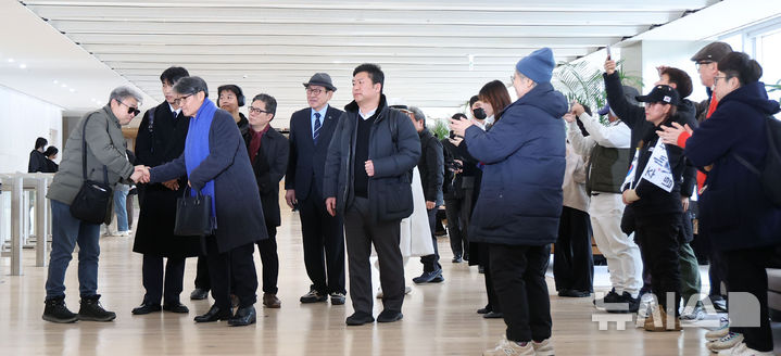 [서울=뉴시스] 김선웅 기자 = 최재영 목사가 9일 서울 종로구 김건희특검팀(특별검사 민중기)에서 열리는 '디올백 수수 의혹' 관련 참고인 조사에 출석하며 동행한 지인들과 인사를 나누고 있다.  최 목사는 지난 2022년 9월 당시 영부인 김건희 여사에게 300만원 상당의 디올백을 선물하고 이 과정을 몰래 촬영해 인터넷에 유포한 바 있다. 2025.12.09. mangusta@newsis.com