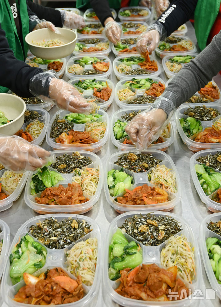 [수원=뉴시스] 김종택 기자 = 9일 경기 수원시 권선구 평동 행정복지센터에서 새마을 부녀회 회원들이 관내 독거노인 등 취약계층에 전달할 반찬을 만들어 용기에 담고 있다. 2025.12.09. jtk@newsis.com
