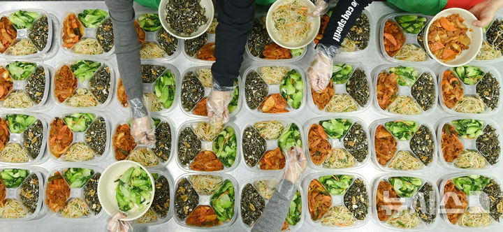 [수원=뉴시스] 김종택 기자 = 9일 경기 수원시 권선구 평동 행정복지센터에서 새마을 부녀회 회원들이 관내 독거노인 등 취약계층에 전달할 반찬을 만들어 용기에 담고 있다. 2025.12.09. jtk@newsis.com