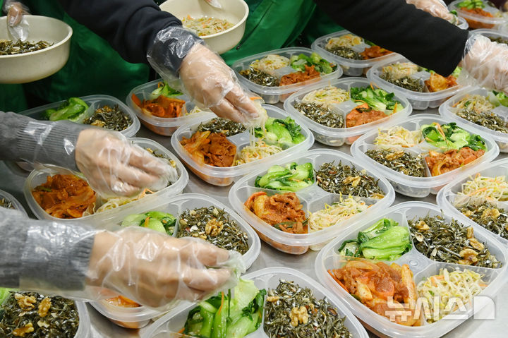 [수원=뉴시스] 김종택 기자 = 9일 경기 수원시 권선구 평동 행정복지센터에서 새마을 부녀회 회원들이 관내 독거노인 등 취약계층에 전달할 반찬을 만들어 용기에 담고 있다. 2025.12.09. jtk@newsis.com