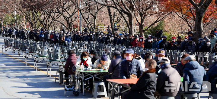 [대구=뉴시스] 이무열 기자 = 쌀쌀한 날씨를 보인 9일 대구 달서구 두류공원 사랑해밥차 무료 급식소를 찾은 어르신들이 점심 배식을 받기 위해 줄을 서고 있다. 2025.12.09. lmy@newsis.com