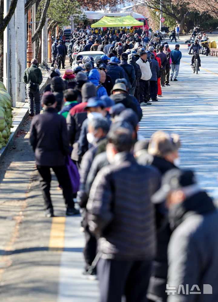 [대구=뉴시스] 이무열 기자 = 쌀쌀한 날씨를 보인 9일 대구 달서구 두류공원 사랑해밥차 무료 급식소를 찾은 어르신들이 점심 배식을 받기 위해 줄을 서고 있다. 2025.12.09. lmy@newsis.com