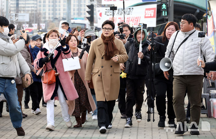 [서울=뉴시스] 김금보 기자 = 한동훈 국민의힘 전 대표가 9일 오후 서울 여의도 국회 앞에서 제2연평해전 영웅 고 한상국 상사 아내 김한나 씨의 지연성 PTSD 법 입법 촉구 1인 시위에 동참하고 있다. 2025.12.09. kgb@newsis.com