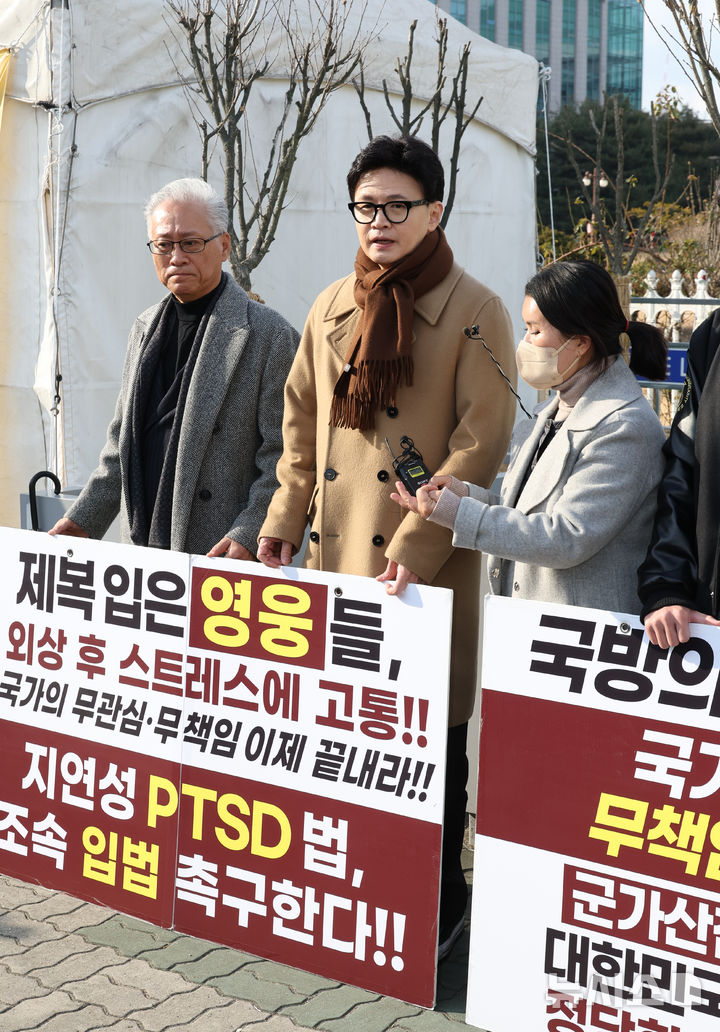 [서울=뉴시스] 김금보 기자 = 한동훈 국민의힘 전 대표가 9일 오후 서울 여의도 국회 앞에서 제2연평해전 영웅 고 한상국 상사 아내 김한나 씨의 지연성 PTSD 법 입법 촉구 1인 시위에 동참하고 있다. 2025.12.09. kgb@newsis.com