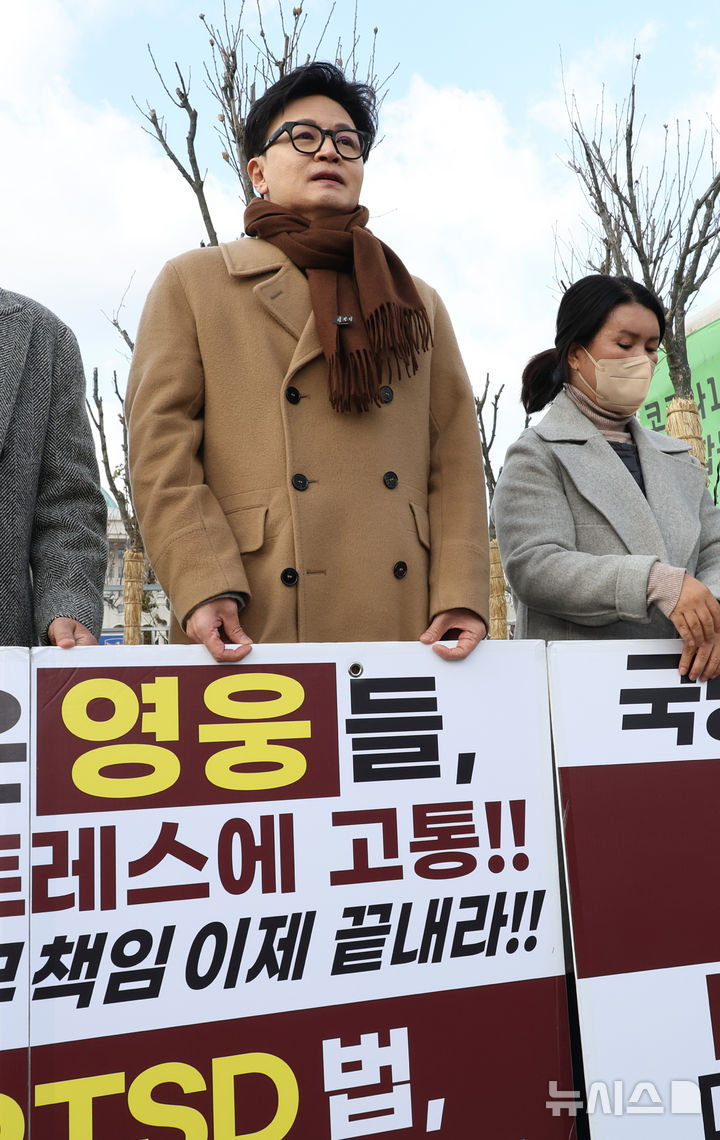 [서울=뉴시스] 김금보 기자 = 한동훈 국민의힘 전 대표가 9일 오후 서울 여의도 국회 앞에서 제2연평해전 영웅 고 한상국 상사 아내 김한나 씨의 지연성 PTSD 법 입법 촉구 1인 시위에 동참하고 있다. 2025.12.09. kgb@newsis.com