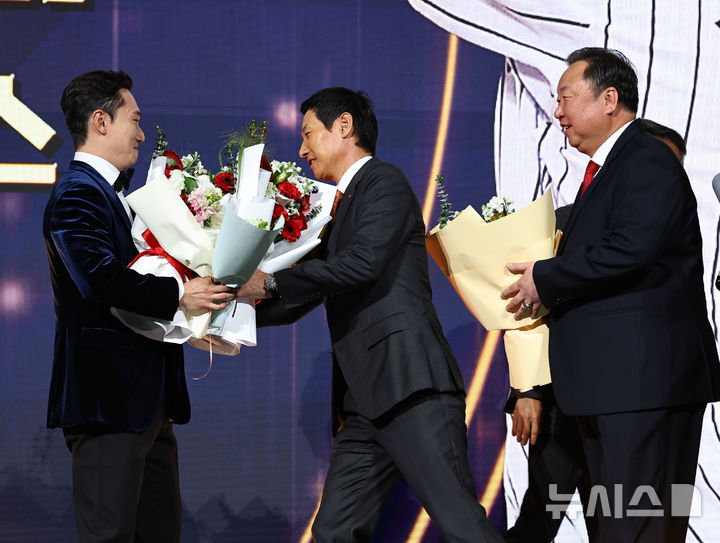 [서울=뉴시스] 최진석 기자 = LG 트윈스 신민재가 9일 서울 송파구 롯데호텔 월드에서 열린 '2025 KBO 골든글러브 시상식'에서 2루수 골든글러브를 수상하며 염경엽 감독, 차명석 단장의 꽃다발을 받고 있다. 2025.12.09. myjs@newsis.com