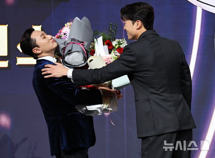 [서울=뉴시스] 최진석 기자 = LG 트윈스 신민재가 9일 서울 송파구 롯데호텔 월드에서 열린 '2025 KBO 골든글러브 시상식'에서 2루수 골든글러브를 수상하며 박해민의 꽃다발을 받고 있다. 2025.12.09. myjs@newsis.com