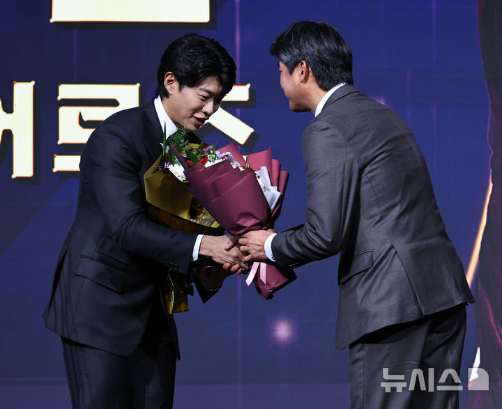 [서울=뉴시스] 최진석 기자 = 키움 히어로즈 송성문이 9일 서울 송파구 롯데호텔 월드에서 열린 '2025 KBO 골든글러브 시상식'에서 3루수 골든글러브를 수상한 뒤 꽃다발을 받고 있다. 2025.12.09. myjs@newsis.com