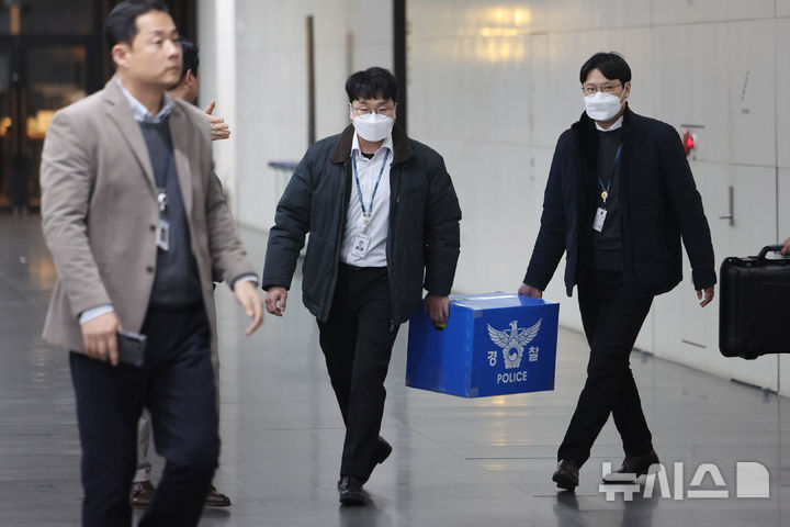 [서울=뉴시스] 최진석 기자 = 경찰이 대규모 개인정보 유출 사태를 빚은 쿠팡을 상대로 강제수사에 나선 9일 오후 서울 송파구 쿠팡 본사 사무실에서 압수수색을 마친 경찰들이 압수품을 옮기고 있다. (공동취재) 2025.12.09. photo@newsis.com