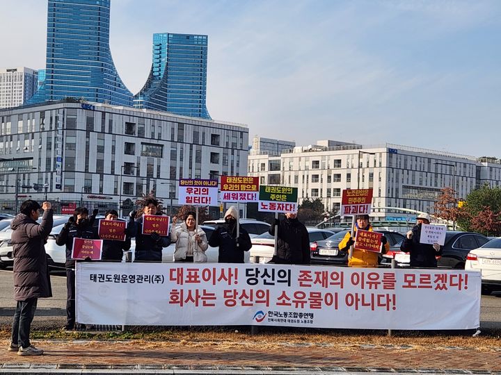 [세종=뉴시스] 10일 세종특별자치시 세종정부청사 인근에서 한국노동조합총연맹 태권도원 노동조합 관계자들이 집회를 열고 태권도원운영관리 주식회사 대표이사의 해임을 촉구함과 동시에 문화체육관광부가 이를 조속히 해결하라고 주장하고 있다. (사진=한국노동조합총연맹 태권도원 노동조합 제공) 2025.12.10. photo@newsis.com *재판매 및 DB 금지