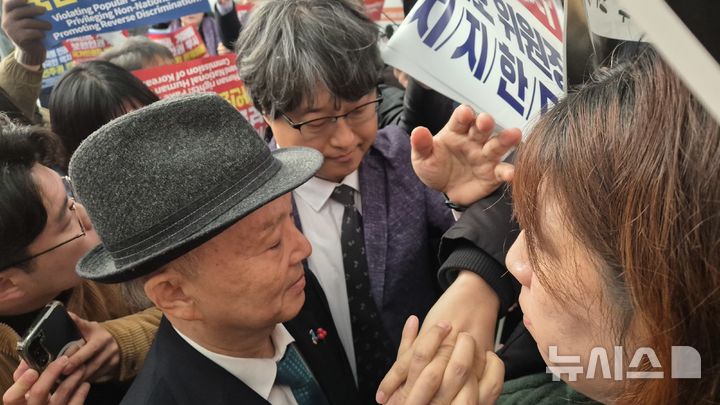 [서울=뉴시스] 전상우 수습기자 = 안창호 국가인권위원회 위원장이 10일 세계인권선언 77주년 인권의 날 기념식에 참석하기 위해 행사장 입구에 도착했으나, 위원장직 사퇴를 촉구하는 시민단체에 막혀 입장하지 못하고 있다. 2025.12.10. swoo@newsis.com *재판매 및 DB 금지