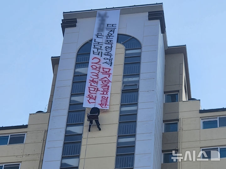 [나주=뉴시스] 10일 오후 1시께 전남 나주시 빛가람동 한 20층 높이 아파트에서 해당 아파트 도장 업체 관계자 A(52)씨가 현수막을 내걸어 체불임금 지급을 촉구하며 고공농성을 벌이고 있다. (사진 = 독자 제공) 2025.12.10. photo@newsis.com