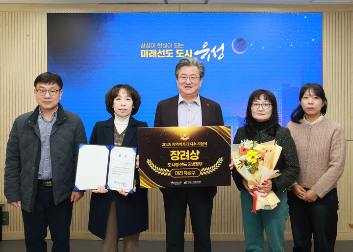 [대전=뉴시스] 조명휘 기자 = 정용래(가운데) 대전 유성구청장과 직원들이 '지역먹거리 지수 평가'에서 '도시형 선도 지방정부상'을 받고 기념촬영을 하고 있다. (사진= 유성구 제공) 2025.12.10. photo@newsis.com *재판매 및 DB 금지