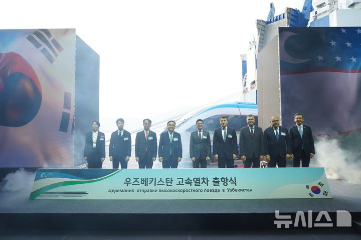 [창원=뉴시스]10일 오후 경남 창원시 성산구 마산항 제4부두에서 열린 현대로템의 우즈베키스탄 고속열차 출항식 주요 참석자들이 기념촬영하고 있다.(사진=현대로템 제공) 2025.12.10. photo@newsis.com
