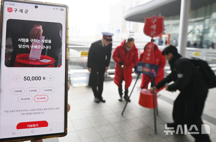 [수원=뉴시스] 김종택 기자 = 구세군 연말 모금 캠페인이 시작된 10일 경기 수원역에서 한 시민이 구세군 자선냄비에 성금을 넣고 있다. 2025.12.10. jtk@newsis.com