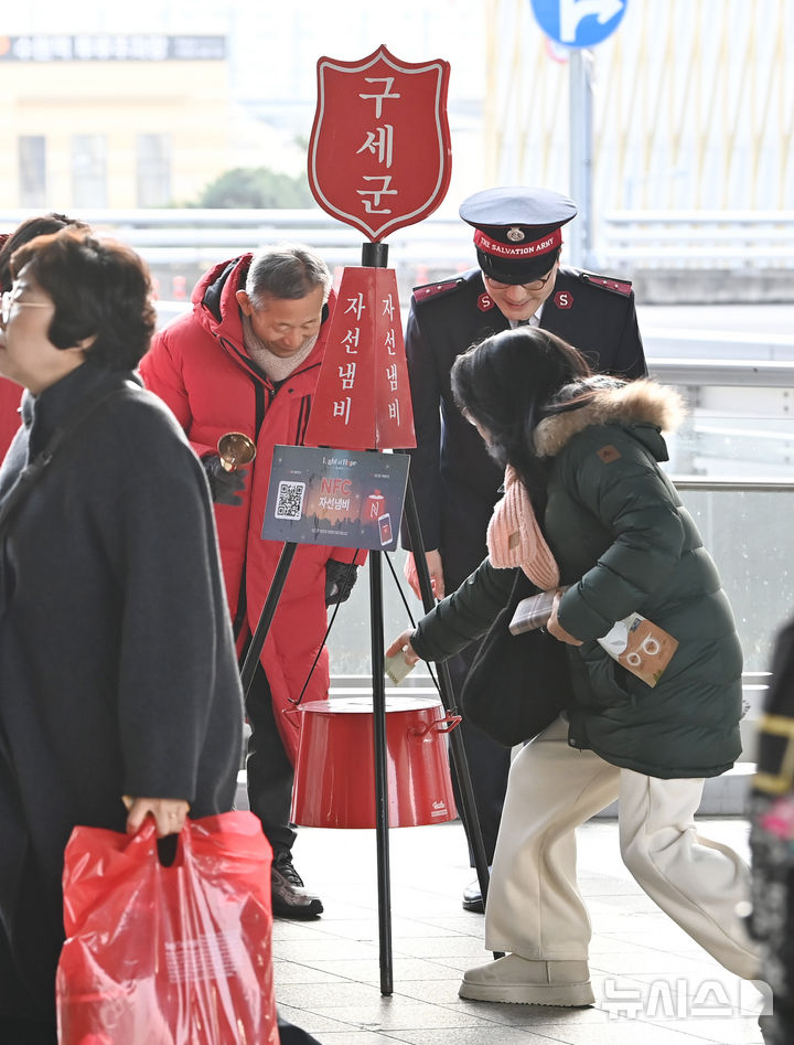 [수원=뉴시스] 김종택 기자 = 구세군 연말 모금 캠페인이 시작된 10일 경기 수원역에서 한 시민이 구세군 자선냄비에 성금을 넣고 있다. 2025.12.10. jtk@newsis.com