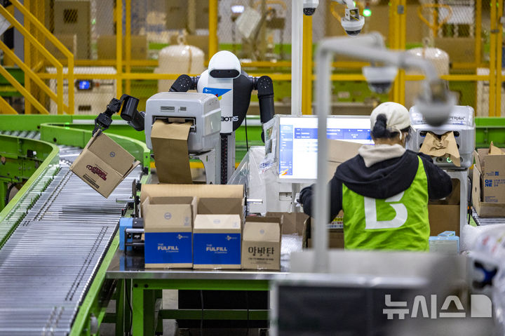 [군포=뉴시스] 정병혁 기자 = 10일 경기 군포시 CJ대한통운 스마트풀필먼트센터에서 AI 휴머노이드 로봇이 완충재 보충, 박스 적재 등 포장 작업을 하고 있다. 2025.12.10. jhope@newsis.com