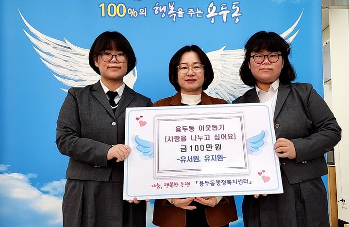 [제천=뉴시스] 이웃돕기 성금 맡기는 제천여고 유지원·서원 자매. (사진=제천시 제공) 2025.12.11. photo@newsis.com  *재판매 및 DB 금지