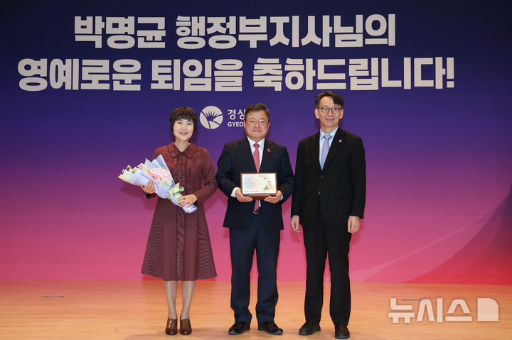 [창원=뉴시스]박명균(가운데) 경남도 행정부지사가 11일 도청 본관 대회의실에서 퇴임식을 갖고 김명주 경제부지사로부터 퇴임 기념패를 받은 후 기념촬영하고 있다.(사진=경남도 제공) 2025.12.11. photo@newsis.com