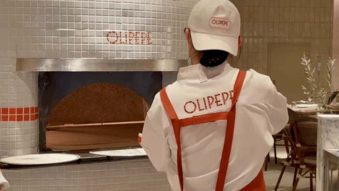 [서울=뉴시스] 한이재 기자 = 11일 문을 연 올리페페 광화문점에서 직원이 갓 구운 피자를 화덕에서 꺼내고 있다. 2025.12.11. nowone@newsis.com *재판매 및 DB 금지