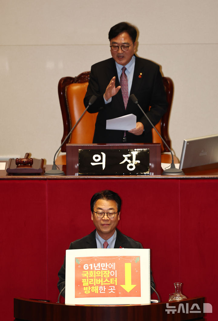 [서울=뉴시스] 김명년 기자 = 곽규택 국민의힘 의원이 11일 오후 서울 여의도 국회 본회의에서 형사소송법 일부개정법률안에 대한 필리버스터(무제한 토론) 도중 우원식 의장이 발언하자 미소를 짓고 있다. 곽 의원은 지난번 본회의에서 벌어진 나경원 의원 토론 중단사태에 대해 항의하는 내용이 적힌 손피켓을 들고 토론에 나섰다. 2025.12.11. kmn@newsis.com