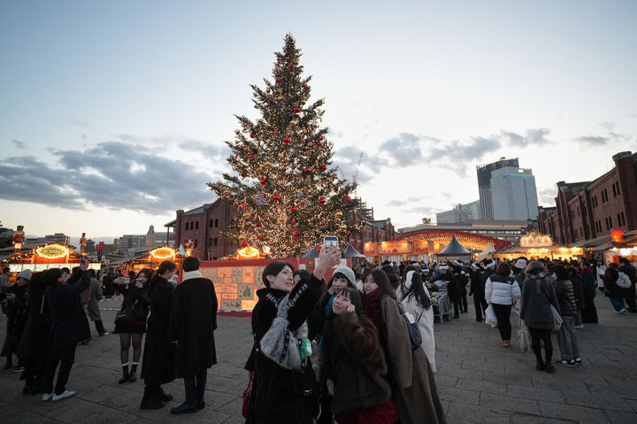 [요코하마=AP/뉴시스]일본 수도인 도쿄도가 민간 데이터센터를 대상으로 환경 영향·지역 공헌 정도를 평가하는 인증 제도를 내년에 신설할 방침을 굳혔다고 29일 요미우리신문이 보도했다. 지난 12일 일본 도쿄 인근 요코하마의 요코하마 레드 브릭 창고에서 열린 크리스마스 마켓에 시민들이 모여있다. 2025.12.29.