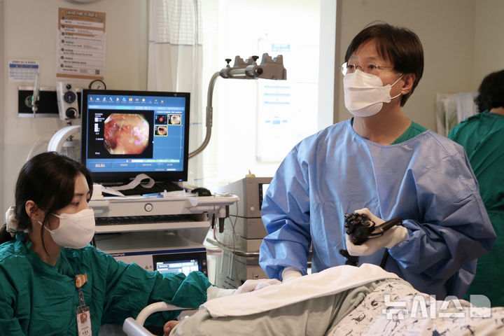[서울=뉴시스] AI 대장내시경은 폴립 발견과 전암·비전암 폴립 감별진단을 돕는다. 사진은 변정식 서울아산병원 소화기내과 교수(오른쪽)가 대장내시경을 시행하고 있는 모습. (사진= 서울아산병원 제공) 