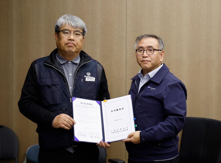 [서울=뉴시스] 한영희(오른쪽) 서울교통공사 사장 직무대행이 12일 오전 서울 성동구 서울교통공사에서 김태균 민주노총 공공운수노조 서울교통공사노조위원장과 임금·단체협약을 체결한 뒤 기념촬영 하고 있다. (사진=서울교통공사 제공) 2025.12.12. photo@newsis.com *재판매 및 DB 금지