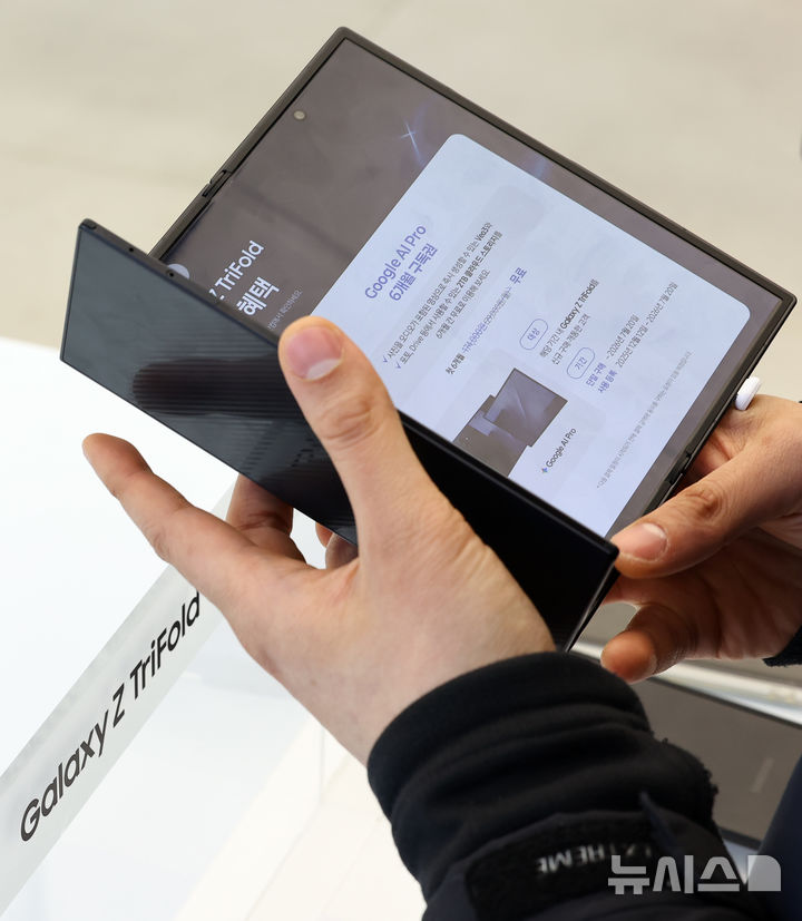 [서울=뉴시스] 최진석 기자 = 두 번 접는 '갤럭시 Z 트라이폴드'의 국내 판매가 시작된 12일 서울 서초구 삼성 강남에서 고객이 갤럭시 Z 트라이폴드를 접어보고 있다. 갤럭시 Z 트라이폴드는 펼치면 253㎜(10형)의 대화면이 나타나고, 접으면 164.8㎜(6.5형)의 휴대성 높은 바(Bar) 타입 화면을 지원하는 새로운 형태의 스마트폰이다. 2025.12.12. myjs@newsis.com