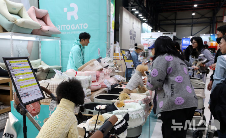 [서울=뉴시스] 김혜진 기자 = 12일 서울 강남구 세텍(SETEC)에서 열린 크리스마스 서울 펫쇼에서 관람객들이 반려견과 함께 전시장을 둘러보고 있다. 2025.12.12. jini@newsis.com