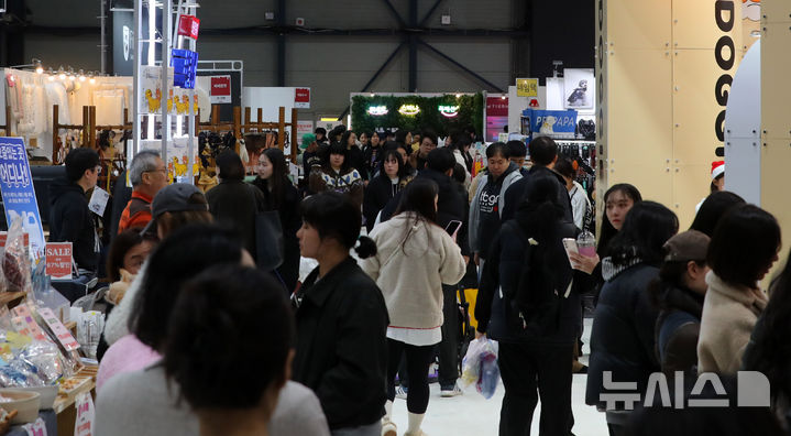 [서울=뉴시스] 김혜진 기자 = 12일 서울 강남구 세텍(SETEC)에서 열린 크리스마스 서울 펫쇼에서 관람객들이 반려견과 함께 전시장을 둘러보고 있다. 2025.12.12. jini@newsis.com