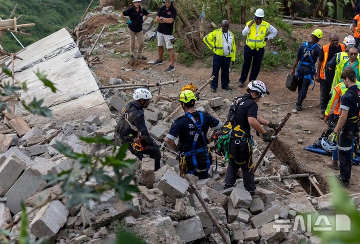 [AP/뉴시스] 지난 12일 남아공 더반 다층건물 건설현장 붕괴 현장으로 구조대가 수색하고 있다. 당시 5명이 사망했다.