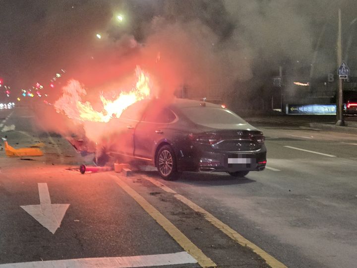 [부산=뉴시스] 13일 오전 부산 해운대구의 한 교차로에서 A(30대)씨가 몰던 차량이 중앙분리대를 들이받는 사고를 내 화재가 발생했다. (사진=독자 제공) *재판매 및 DB 금지