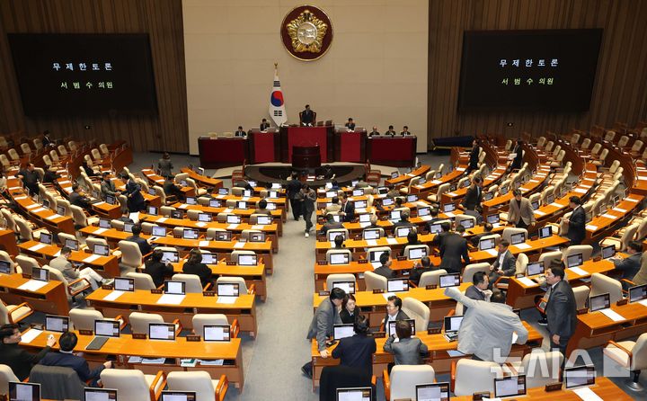 [서울=뉴시스] 조성봉 기자 = 서범수 국민의힘 의원이 13일 오후 서울 여의도 국회에서 열린 본회의에서 경찰관직무집행법 일부개정법률안에 대한 무제한토론(필리버스터)을 시작하자 더불어민주당 의원들이 자리에서 일어나고 있다.2025.12.13. suncho21@newsis.com