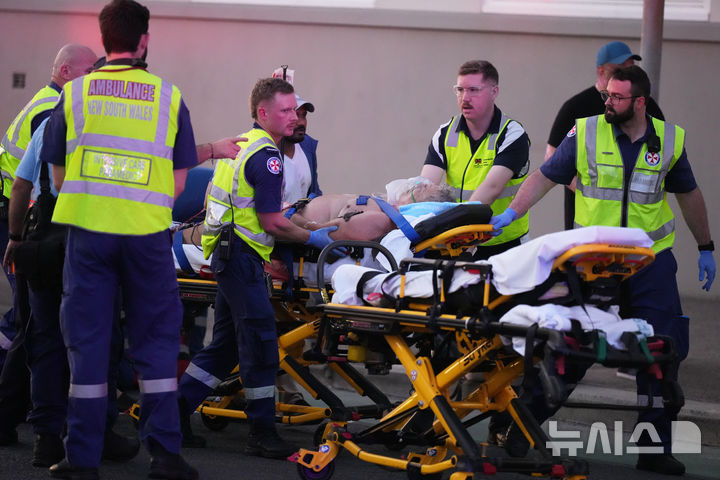 [AP/뉴시스] 14일 저녁 호주 시드니 본디 해변에서 군중 타깃 무차별 총격 사건이 발생한 후 구조대가 부상자를 옮기고 있다