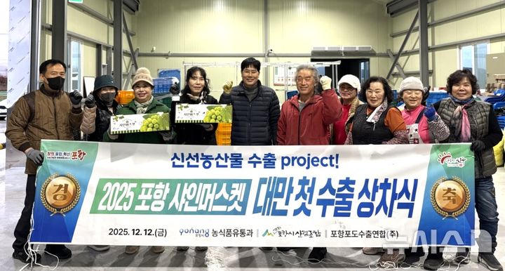 [포항=뉴시스] 송종욱 기자 = 지난 12일 북구 흥해읍 포항시산림조합에서 지역 포도 재배 농업인과 시 농업기술센터 관계자가 포항에서 생산한 포도 '샤인머스캣' 4t을 대만으로 수출하기 위해 차에 싣고 기념 촬영하고 있다. (사진=포항시 제공) 2025.12.14. photo@newsis.com  