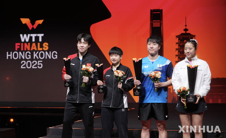 [홍콩=신화/뉴시스] 임종훈과 신유빈(오른쪽)이 13일(현지 시간) 중국 홍콩에서 열린 2025 월드테이블테니스(WTT) 홍콩 파이널스 혼합 복식 정상에 올라 시상대에서 트로피를 들고 포즈를 취하고 있다. 임종훈-신유빈 조는 결승에서 왕추친-쑨잉사 조(중국)를 3-0(11-9 11-8 11-6)으로 완파하고 한국 선수로는 처음으로 우승을 차지했다. 2025.12.14. 