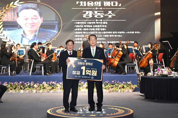 [울산=뉴시스] 15일 울산 남구청 대강당에서 '외황강 역사문화권 장편소설 전국 공모전(외황강 문학상) 당선작 시상식'이 열린 가운데 서동욱 남구청장이 강동수 당선작가(왼쪽)에게 상패와 상금을 수여하고 있다. (사진=울산 남구 제공) 2025.12.15. photo@newsis.com *재판매 및 DB 금지