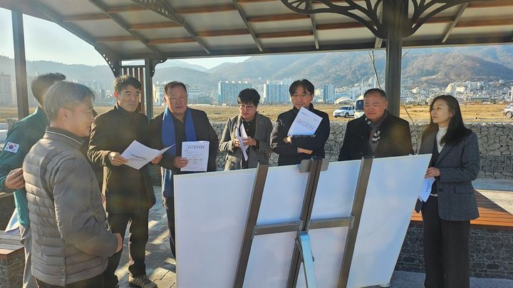 [창원=뉴시스] 강경국 기자 = 경남 창원시의회 건설해양농림위원회 위원들이 15일 마산해양신도시 조성 현장을 방문해 기반시설 구축 현형을 설명 듣고 있다. (사진=창원시의회 제공). 2025.12.15. photo@newsis.com *재판매 및 DB 금지