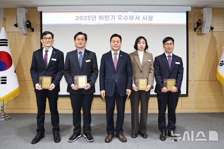 [창원=뉴시스]15일 경남도청 도정회의실에서 박완수(가운데) 도지사가 '2025년 하반기 우수 부서 10곳' 중 최우수 부서로 뽑힌 투자유치과(왼쪽부터), 도로과, 건설지원과, 수자원과 4개 부서 과장에게 상장을 수여한 후 기념촬영하고 있다.(사진=경남도 제공) 2025.12.15. photo@newsis.com