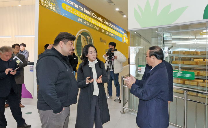 [임실=뉴시스] 지난 12일 임실 치즈테마파크를 방문한 애니메이션 '심슨가족'의 연출자 랄프 소사 감독(왼쪽)에게 심민 임실군수(오른쪽)가 故지정환 신부로부터 이어져 온 임실N치즈의 역사를 설명하고 있다. *재판매 및 DB 금지