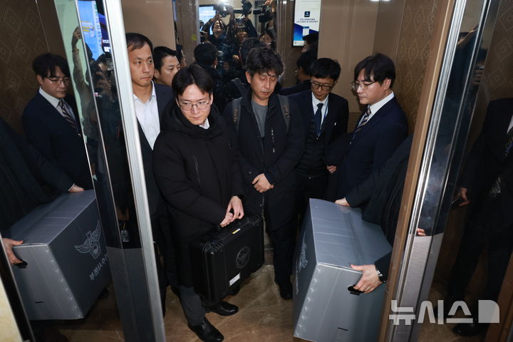 [서울=뉴시스] 고승민 기자 = 경찰이 통일교 관련 전방위적으로 압수수색에 나선 15일 서울 여의도 국회 의원회관 전재수 더불어민주당 의원실 압수수색을 마친 경찰 국가수사본부 관계자가 압수물품을 들고 건물을 나서고 있다. 2025.12.15. kkssmm99@newsis.com