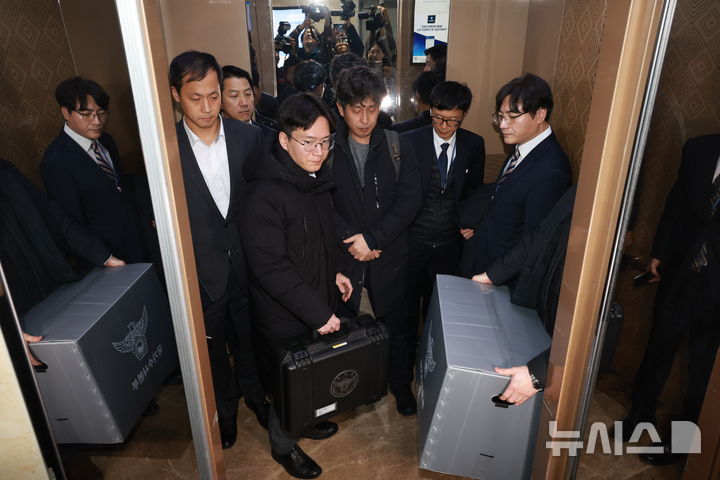 [서울=뉴시스] 고승민 기자 = 경찰이 통일교 관련 전방위적으로 압수수색에 나선 15일 서울 여의도 국회 의원회관 전재수 더불어민주당 의원실 압수수색을 마친 경찰 국가수사본부 관계자가 압수물품을 들고 건물을 나서고 있다. 2025.12.15. kkssmm99@newsis.com