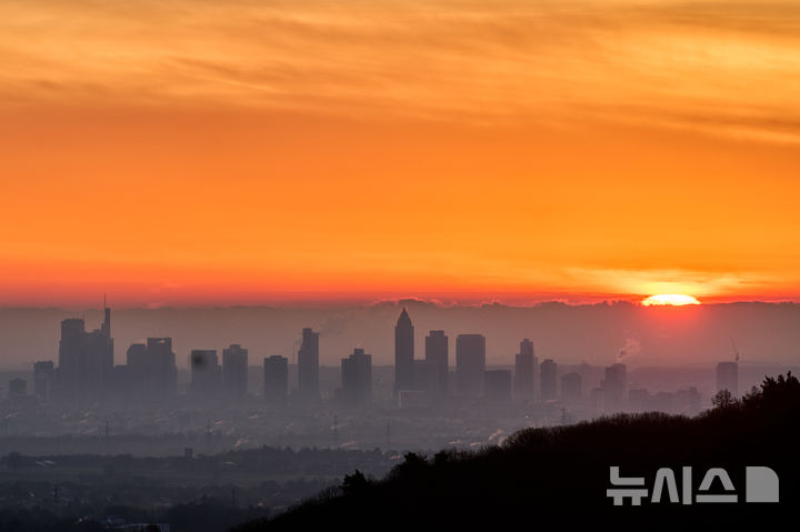 [AP/뉴시스] 16일 새벽 독일 프랑크푸르크 금융가의 하늘이 여명에 물들어 있다.