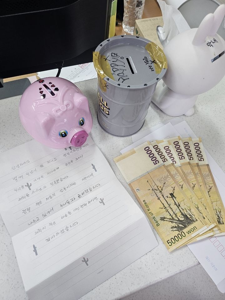 [보령=뉴시스] 익명의 기부자가 기탁한 저금통과 현금, 손편지. (사진=보령시청 제공) 2025.12.16. photo@newsis.com *재판매 및 DB 금지