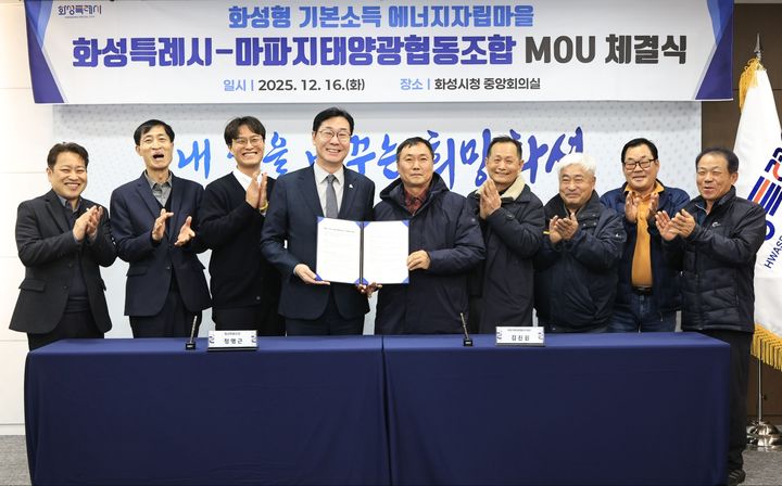 [화성=뉴시스]정명근 화성시장(사진 왼쪽 네 번째)이 16일 김진원 마파지태양광협동조합 조합장(사진 왼쪽 다섯 번째)과 '화성형 기본소득 에너지자립마을 조성을 위한 업무협약'을 체결하고 기념촬영을 하고 있다.(사진=화성시 제공02025.12.16.photo@newsis.com *재판매 및 DB 금지