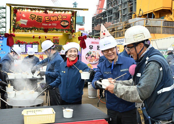 [울산=뉴시스] 16일 HD현대중공업 금석호 사장(오른쪽 두번째)이 찾아가는 간식차 '우동 드쎄오' 앞에서 직원들에게 우동을 나눠주고 있다. (사진=HD현대중공업 제공) 2025.12.16. photo@newsis.com *재판매 및 DB 금지