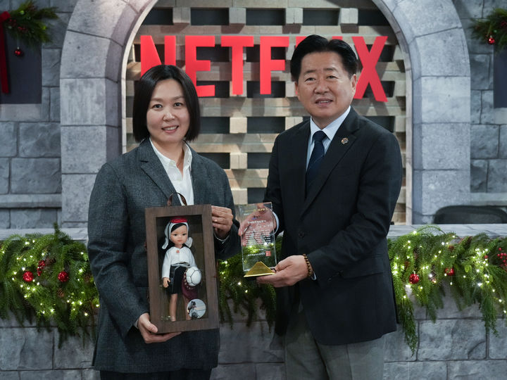 [제주=뉴시스] 16일 오영훈 제주지사가 넷플릭스서비스코리아에서 김민영 넷플릭스 아시아태평양 콘텐츠 부문 VP에게 명예도민증을 전달하고 있다. (사진=제주도 제공) 2025.12.16. photo@newsis.com *재판매 및 DB 금지